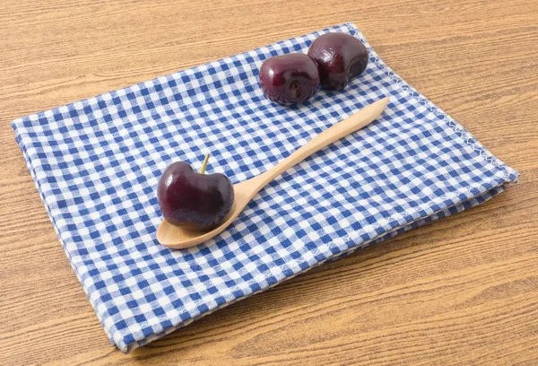 Fresh Fruits, Pile of Ripe and Sweet Red Plums A Very Good Source of Vitamin C on Blue and White Checked Napkin.