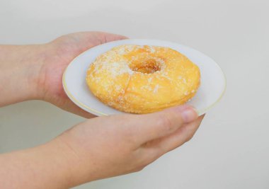 Şeker ile lezzetli sırlı Donut tutan el
