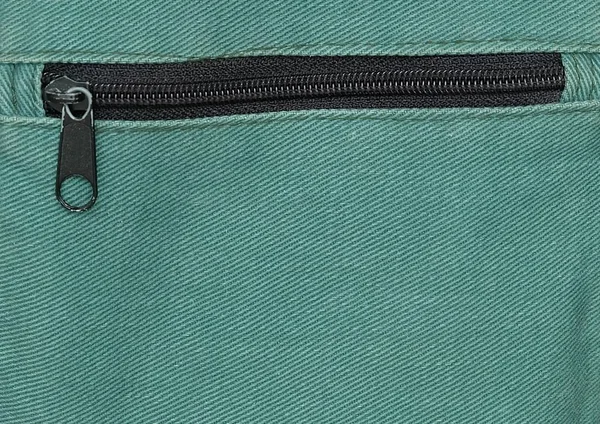 Крупним планом блискавка на фоні зеленої сумки — стокове фото