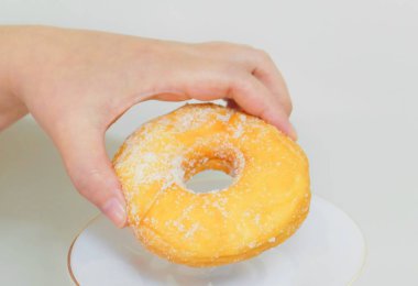 Şeker ile lezzetli sırlı Donut tutan el
