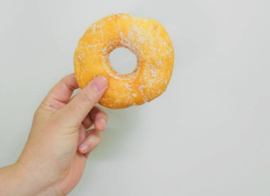 Şeker ile lezzetli sırlı Donut tutan el
