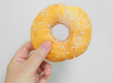 Şeker ile lezzetli sırlı Donut tutan el