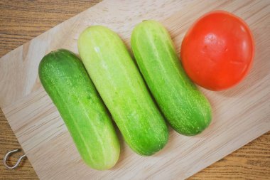 Taze domates salatalık kesme tahtası üzerinde