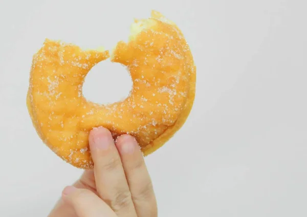 Handen håller Delicious biten Donut socker — Stockfoto