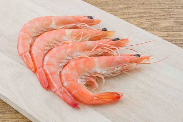 Langostinos cocidos o camarones tigre en una tabla de cortar —  Fotos de Stock