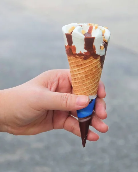 Hand hält Eiszapfen mit Schokolade — Stockfoto