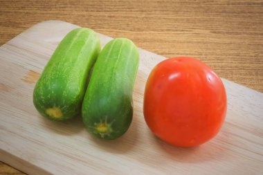 Taze domates salatalık kesme tahtası üzerinde