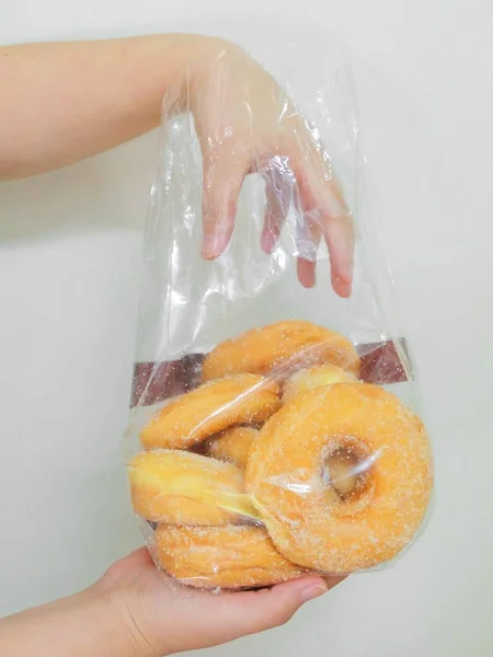 Hand hält eine Tüte Donuts mit Zucker — Stockfoto