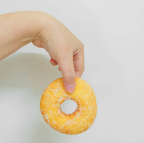 Şeker ile lezzetli sırlı Donut tutan el — Stok fotoğraf
