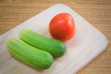 Sebze, taze Ripe domates salatalık ahşap kesme tahtası ile.