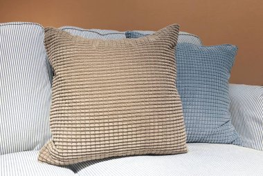 Modern rahat kanepe kahverengi ve gri dekoratif kare yastık veya yastık, yakın çekim.