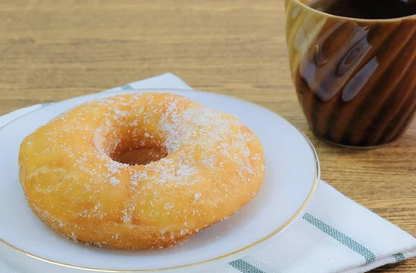 Food and Bakery, Delicious Sweet Donut with Sugar Toppings on A Dish Served with Hot Tea.