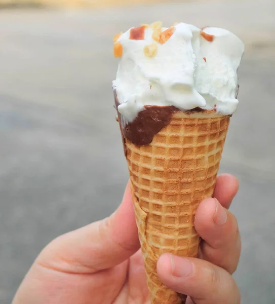 Mão Segurando Sorvete Baunilha Com Chocolate Noz Cone Waffle — Fotografia de Stock