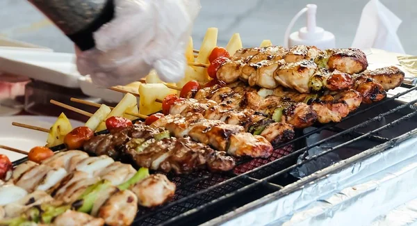 Traditional Grilled Pork and Chicken Meat Barbecue with Tomatoes and Pineapple on The Grill. One of The Most Popular Dish in The World.