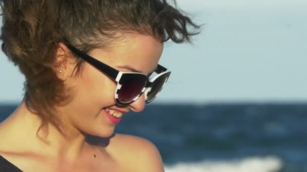 Gesichtsaufnahme einer jungen Frau, die am Meer heftig lacht — Stockvideo