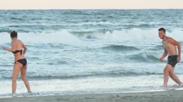 Romántica pareja perfecta jugando en la playa — Vídeo de stock