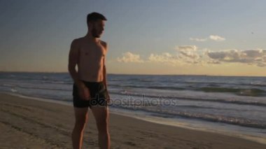 Dinlenme ve yeniden yayınlanmaya sahilde egzersiz yapıyor runner