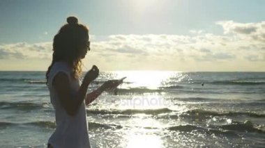 Plajda çalışan kulaklıklar ile genç seksi kadın