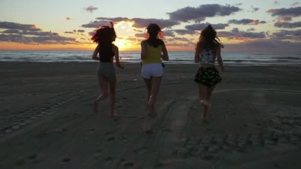 Grupo de adolescentes corriendo en la playa hacia el mar al amanecer — Vídeos de Stock