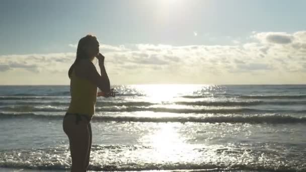 Kulaklıklar koyarak ve sahilde koşu kadın runner — Stok video