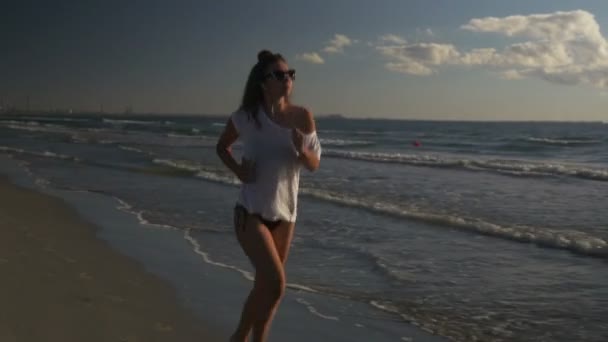 Красивая спортсменка занимается спортом у моря — стоковое видео
