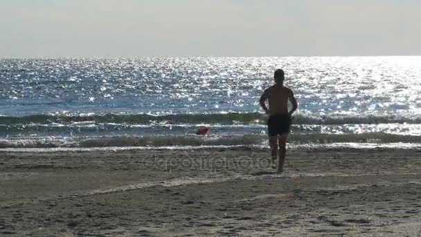 Man kör mot havet på stranden — Stockvideo