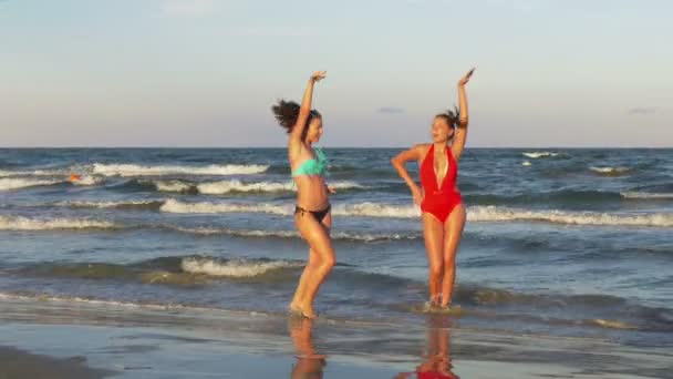 Mujeres jugando en la playa en el agua y bailando — Vídeos de Stock