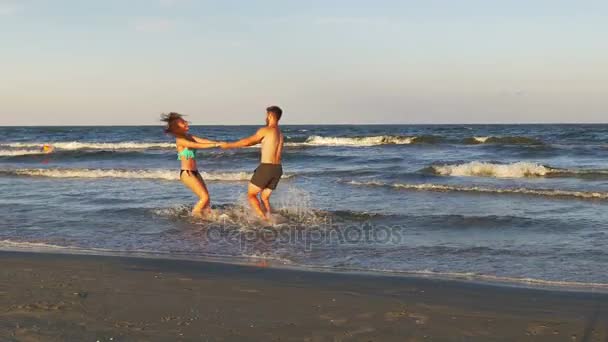 Casal romântico brincando e provocando uns aos outros no mar — Vídeo de Stock