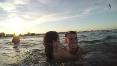 Eğleniyor denizde - kızlar kollarında taşıyan çocuklar çiftler