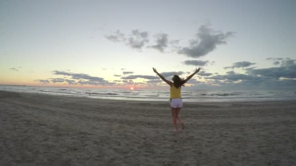 Femme sur une belle plage de sable qui court vers la mer — Video