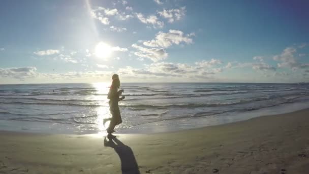 Pareja romántica corriendo por el mar y besándose durante el entrenamiento al aire libre — Vídeos de Stock