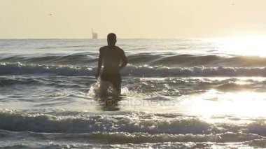 Alacakaranlık deniz suyu yavaş dışarı koşan adam