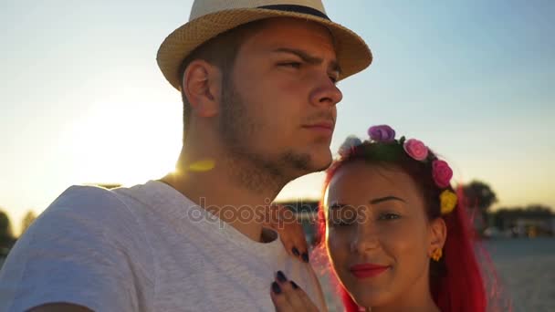 Young couple taking selfie on the beach at sunset — Stock Video