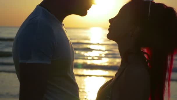 Mujer burlas hombre y besos en la playa al amanecer — Vídeos de Stock