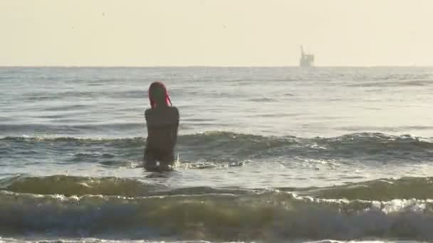 Жінка, що виходить з морських хвиль — стокове відео