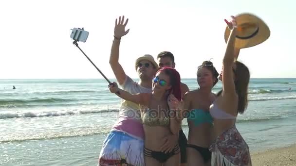 Amigos na praia tendo tirar fotos com um pau de selfie — Vídeo de Stock