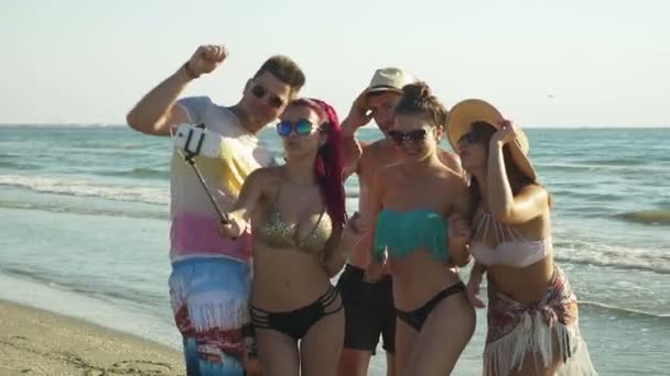 Grupp människor tar selfies och ha ett videosamtal på stranden av en vacker strand — Stockvideo