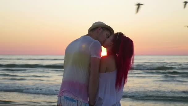 Young beautiful couple watching an amazing sunset and kissing on beach — Stock Video