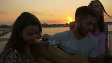 Mutlu bir şekilde şarkı deniz kenarında genç güzel genç grup