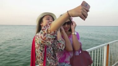 Kızlar selfie ile denizin bir arka plan olarak bir duba taking