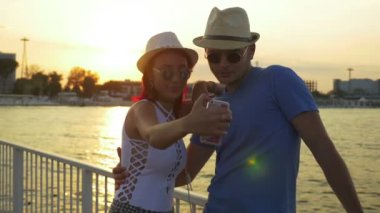 Bir duba üzerinde günbatımında çift alarak selfie