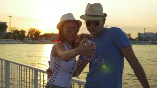 Couple prenant selfie au coucher du soleil sur un ponton — Video