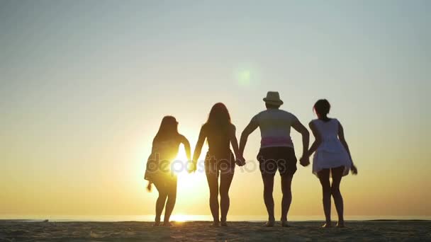 Группа друзей, прыгающих на песчаном пляже — стоковое видео