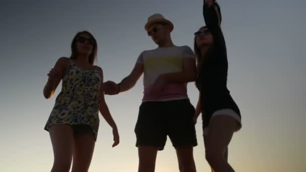 Tres amigos bailando en la playa al atardecer — Vídeo de stock