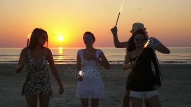 Parti sahilde günbatımı bir havai fişek ile