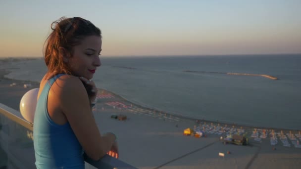 Hermosa joven adolescente contemplando el paisaje en una terraza con vista al mar — Vídeos de Stock