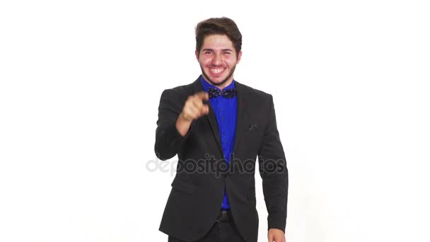 Glücklicher junger unüberzeugter Mann auf weißem Hintergrund, der mit dem Finger zeigt — Stockvideo