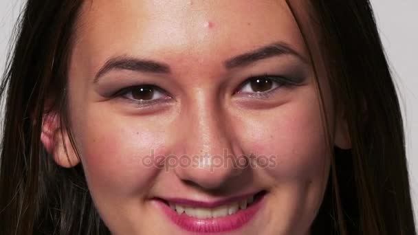 De cerca retrato de una joven sonriendo y luego poniéndose triste y luego sonriendo de nuevo — Vídeo de stock