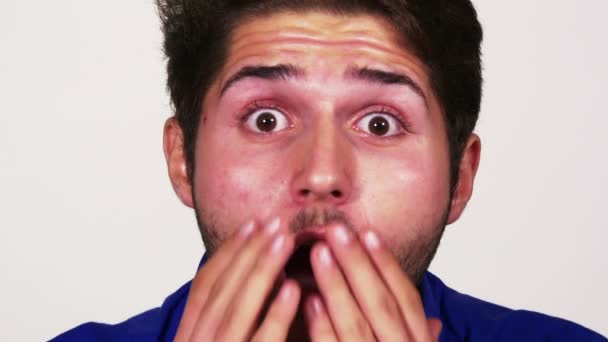 Portrait close up of amazed young man covering his mouth — Stock Video