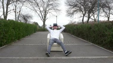 Sanal gerçeklik gözlük takan bir park bir koltukta oturan öğrencinin rahat